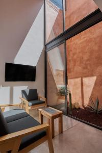 ein Wohnzimmer mit einem großen Fenster und einem Sofa in der Unterkunft Hermosa casa ubicada en Oaxaca in Oaxaca de Juárez