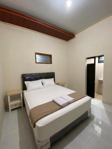a bedroom with a large bed in a room at Nawasena Guesthouse Jogja in Kalasan