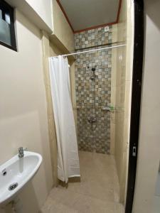 a bathroom with a shower and a sink at Nawasena Guesthouse Jogja in Kalasan