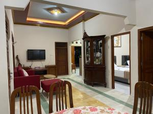 a living room with a couch and a tv at Nawasena Guesthouse Jogja in Kalasan