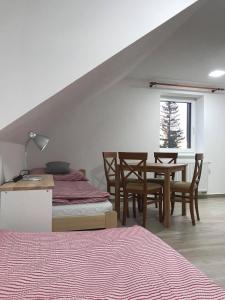 - une chambre avec un lit et une table avec des chaises dans l'établissement Apartmány v Chalupě nad Modravou, à Modrava