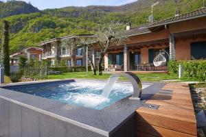 a pool with a water fountain in a yard at Villa Vittoria with private seasonal heated pool & shared sauna - Bellagio Village Residence in Oliveto Lario