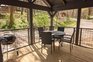 a screened porch with a table and chairs and a grill at Jake Cabin Luxury Hot Tub Cabin Near Downtown in Chattanooga