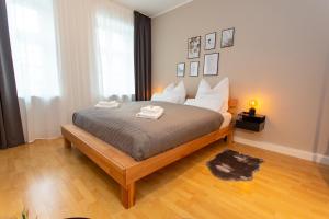 um quarto com uma cama grande e piso em madeira em Das City-Appartment Zentrum West em Leipzig