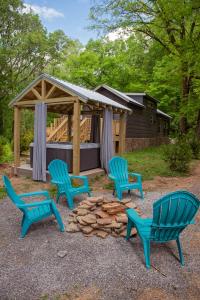 three blue chairs and a fire pit in front of a cabin at Jake Cabin Luxury Hot Tub Cabin Near Downtown in Chattanooga