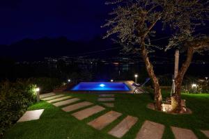 a swimming pool in the middle of a yard at night at Villa Vittoria with private seasonal heated pool & shared sauna - Bellagio Village Residence in Oliveto Lario