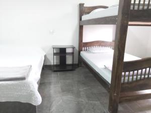 a bedroom with two bunk beds and a table at Hostal y Camping Los Girasoles in Salento