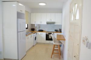 a kitchen with white cabinets and a table and chairs at Modern 2bd appartment near mall- Internet 1Gbps in Paphos