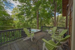 a deck with rocking chairs and a hot tub at Kai Cabin Wauhatchie Woodlands Close To Downtown in Chattanooga