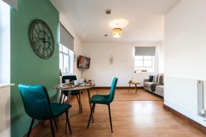 a living room with a table and chairs and a clock at City Centre 1-bedroom apartment - Close to Solent-Hospital-Free Parking in Southampton