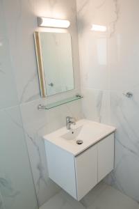 a white bathroom with a sink and a mirror at Modern 2bd appartment near mall- Internet 1Gbps in Paphos +29 photos