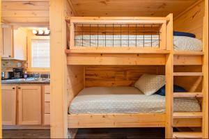 a bedroom with two bunk beds in a log cabin at Lena Cabin Wooded Tiny Cabin - Hot Tub in Chattanooga