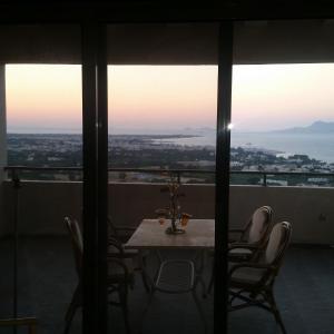 einen Tisch und Stühle in einem Zimmer mit Aussicht in der Unterkunft Hercules Hills Sea View Villas in Kos-Stadt
