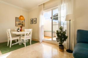 a living room with a table and chairs and a window at Penthouse Apartment in Benalmadena in Benalmádena