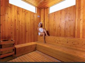 una mujer sentada en el interior de una sauna en Apartamento de Lujo A,C y Agua Caliente, en Neiva