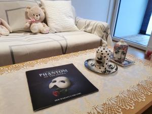 a living room with a table with a book and a teddy bear at Homestay Room in Apartment with Stunning Thames River View in London