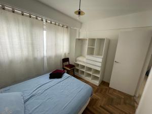 1 dormitorio pequeño con 1 cama y 1 silla en Departamento en alquiler temporal mar del plata en Mar del Plata