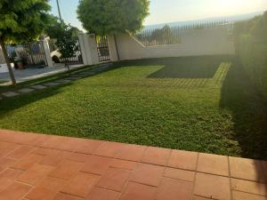a yard with a brick walkway and a green lawn at L'isola di Gianni by Ortigia Apartments in Plemmirio