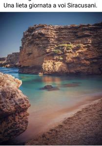 a view of a beach with a rocky cliff at L'isola di Gianni by Ortigia Apartments in Plemmirio