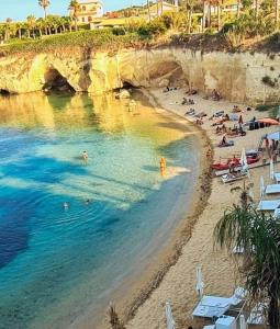 a beach with a bunch of people in the water at L'isola di Gianni by Ortigia Apartments in Plemmirio