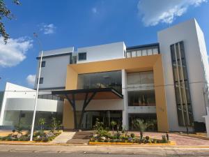 duży biały budynek z dużymi oknami w obiekcie Hotel Cinco Diamantes w mieście Atotonilco el Alto