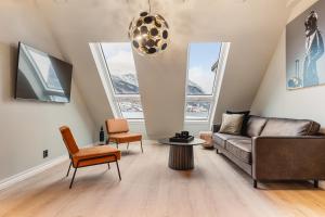 a living room with a couch and chairs and windows at Odda Panorama in Odda
