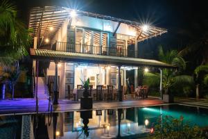 a villa with a swimming pool at night at Style Villa in Bentota