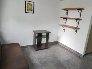 um quarto com uma mesa e uma prateleira na parede em Hostal y Camping Los Girasoles em Salento