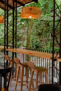 een houten tafel en stoelen op een veranda bij Hotel Casa de Hadas in Minca