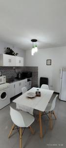 cocina con mesa blanca y sillas blancas en Alojamiento Cuchi Corral en San Luis