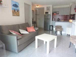 sala de estar con sofá, mesa y cocina en PCOGBLAN - Golfe de Saint-Tropez - T2 avec piscine vue marina, en Cogolin