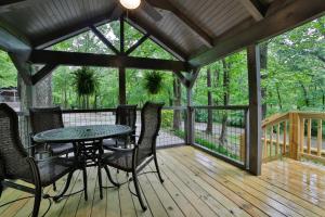 um alpendre com uma mesa e cadeiras em Pops Cabin Lookout Mountain Luxury Tiny Home em Chattanooga