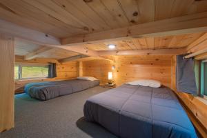 a bedroom with two beds in a log cabin at Papa Cabin Tiny Log Home Comfort In Rustic Bliss in Chattanooga