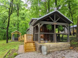 a tiny house with a porch and a deck at Peggers Cabin Luxury Rustic Tiny Cabin Spa in Chattanooga