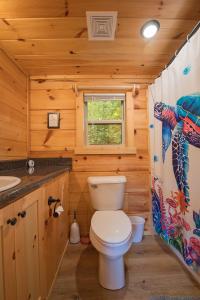 a bathroom with a toilet and a sink at Papa Cabin Tiny Log Home Comfort In Rustic Bliss in Chattanooga