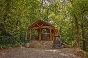 a small building in the middle of a forest at Papa Cabin Tiny Log Home Comfort In Rustic Bliss in Chattanooga