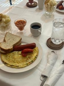 a plate of breakfast food with a hot dog and toast at Post Ridge Hotel in Accra