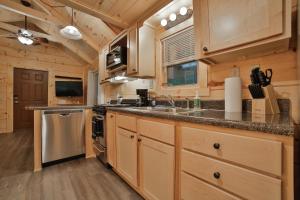 a kitchen with wooden cabinets and a counter top at Ryon Tiny Home Cabin City-side Rustic Retreat in Chattanooga