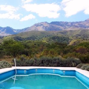 una piscina con montañas en el fondo en La Calandria en Los Hornillos