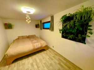 - une chambre avec un lit et des plantes sur le mur dans l'établissement Bydlení v zahradě, à Bratronice