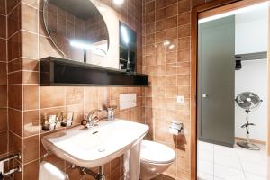 a bathroom with a sink and a toilet and a mirror at Loft Torre Locarno by Quokka 360 - large studio on the city view tower in Locarno