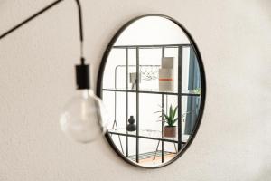 a mirror hanging on a wall with a plant at Loft Torre Locarno by Quokka 360 - large studio on the city view tower in Locarno