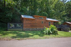 a small wooden cabin with a porch and a balcony at River Cabin Hot Tub & Swim Spa Near Downtown in Chattanooga