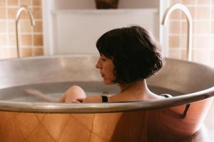 a woman sitting in a metal bath tub at No 42 by GuestHouse, Margate in Margate
