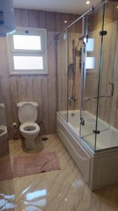 a bathroom with a toilet and a glass shower at Hurghada apartment in Hurghada