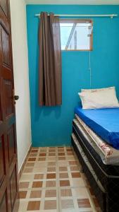 a blue room with a bed and a window at Casa Temporada peterle Iriri in Iriri
