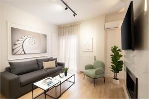 een woonkamer met een bank en een stoel bij Artsy Loft in the heart of Koukaki in Athene
