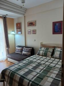 a bedroom with a bed and a couch at Green House in Nea Peramos