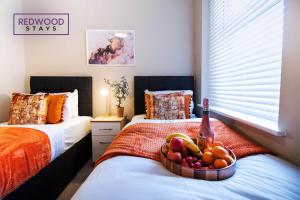 um quarto com 2 camas e uma tigela de fruta em 2 Bedroom 1 Bathroom Town Center Apartment With FREE Parking By REDWOOD STAYS em Basingstoke