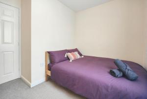 1 dormitorio con 1 cama de color púrpura en una habitación en The Bushmoor - Spacious Holiday Townhouse 10 Minutes to City Centre Free Parking, en Mánchester
